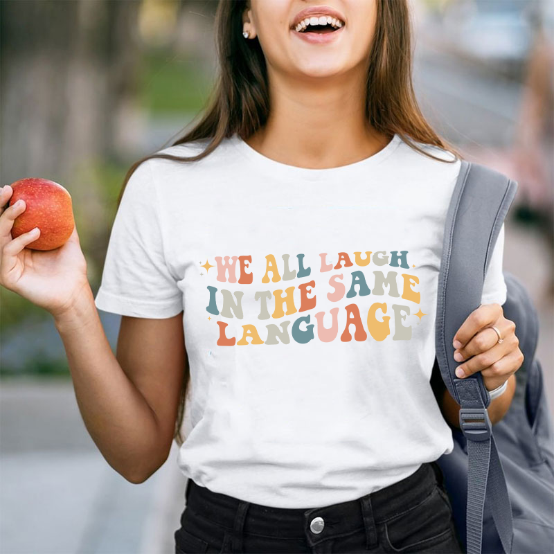 We All Laugh in the Same Language Teacher T-Shirt